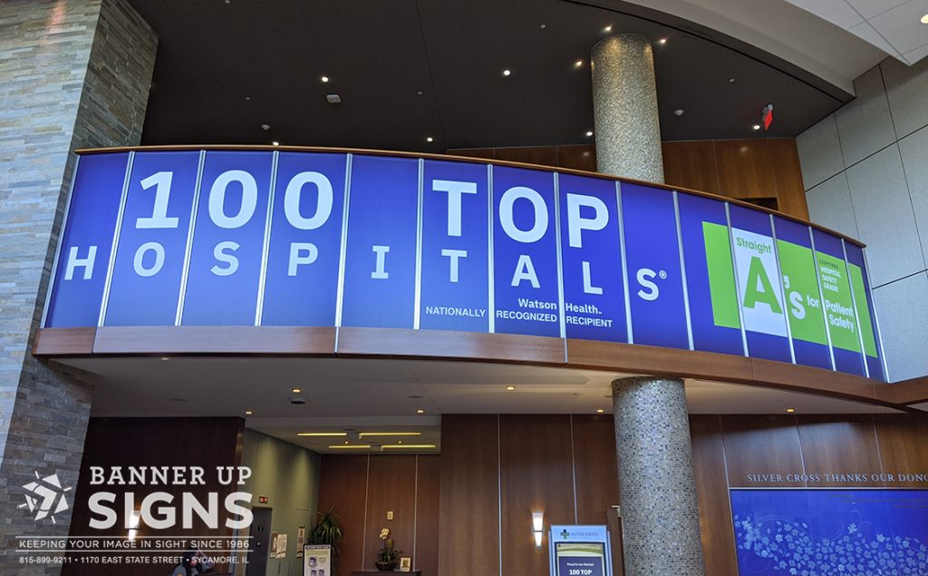 A second story set of windows are fully covered advertising a hospital's celebrated rank as one of the top 100.