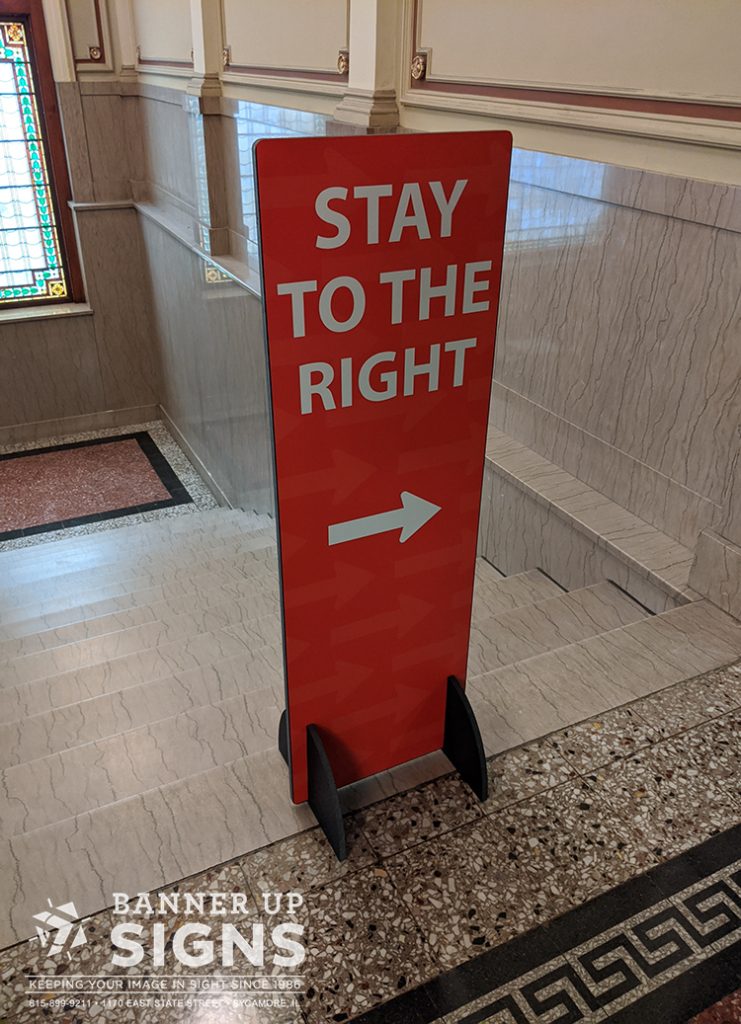 A tall, narrow, free standing directional sign telling patrons to stay to the right.
