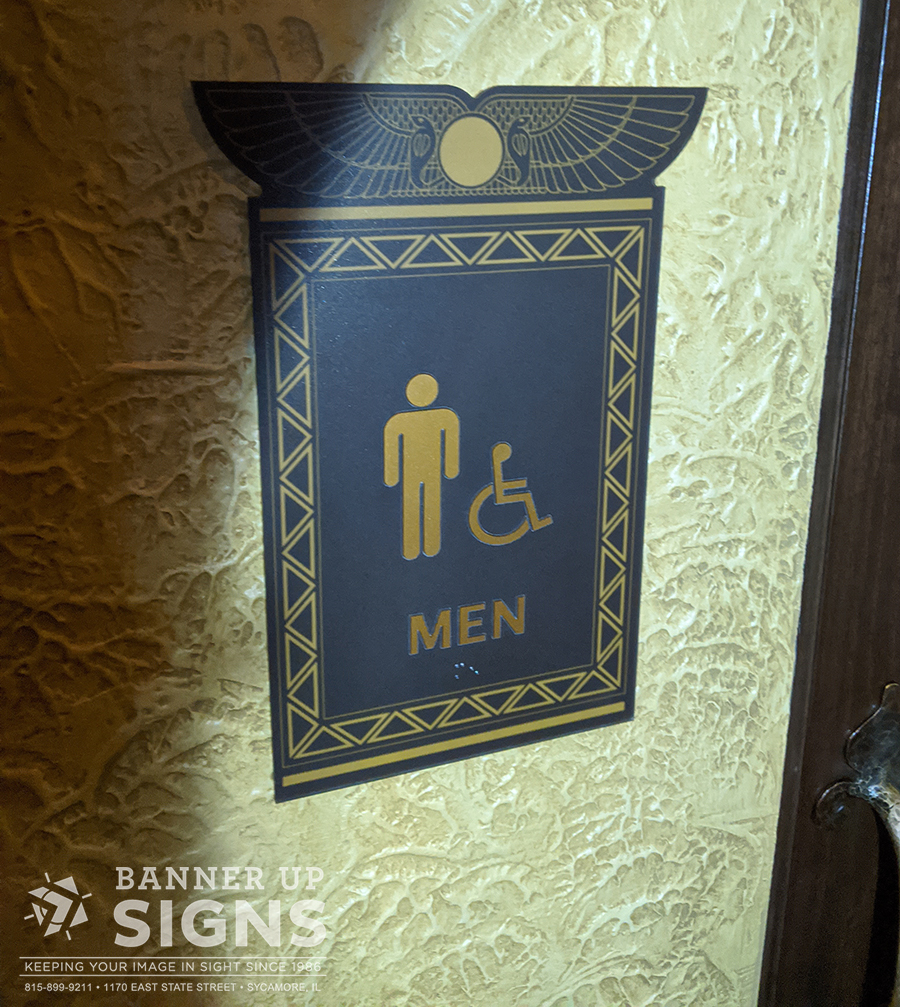Custom ADA restroom sign made from a black material and gold embellishments.