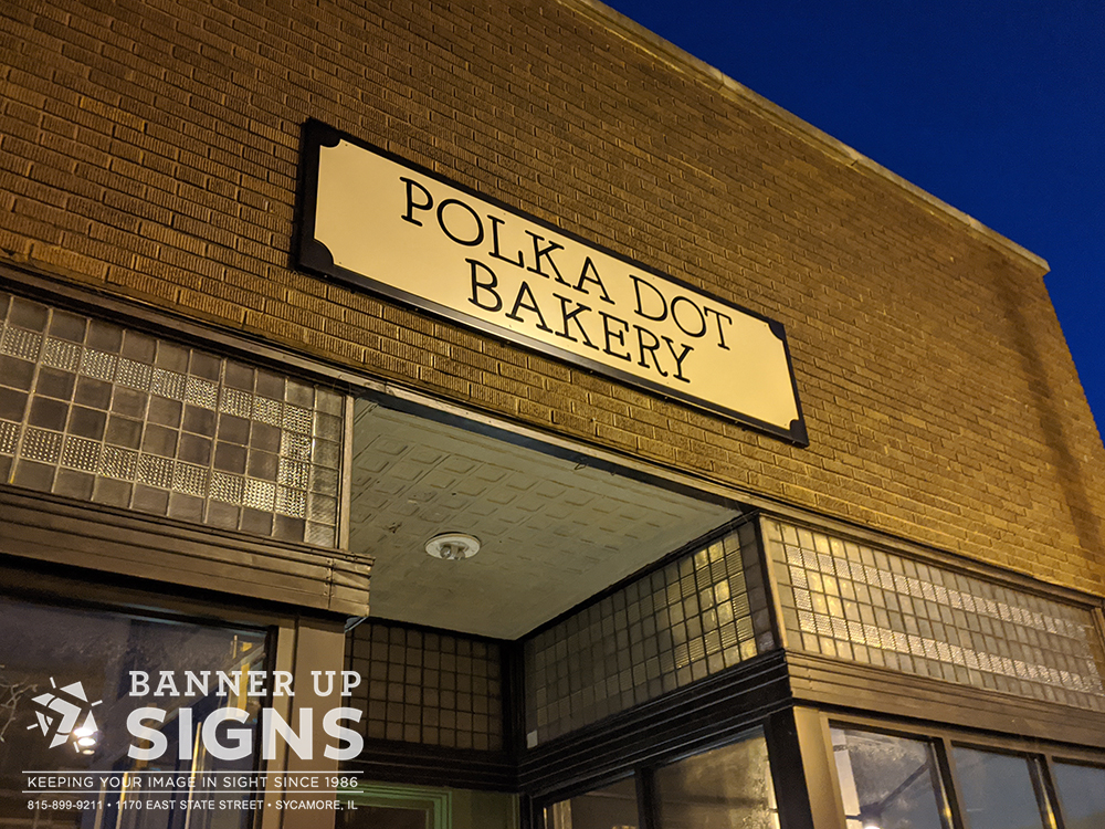 A flat panel with non dimensional graphics notes the entrance for Polka Dot Bakery