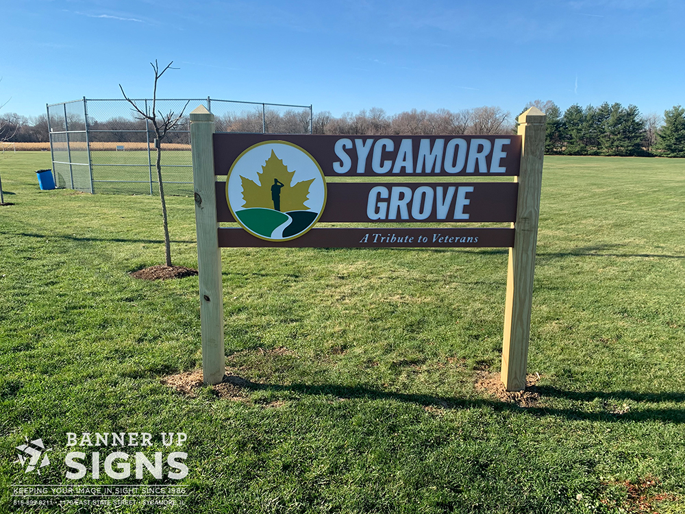 A post sign made of multiple wood panels with dimensional text and a dimensional logo.