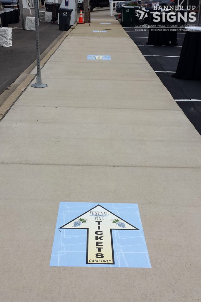 Temporary sidewalk decals direct patrons to a ticket entrance.