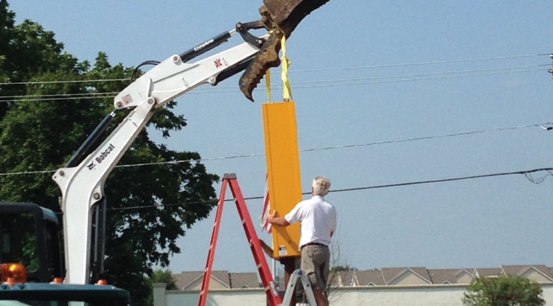 The Banner Up Signs team uses a crane to install an outdoor sign.