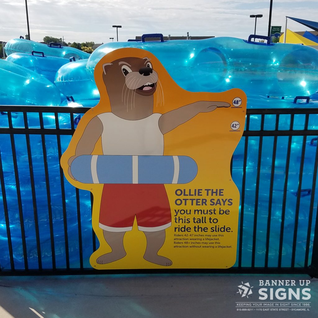 A height sign at a waterpark verifies that those looking to ride the slide are tall enough to ride.