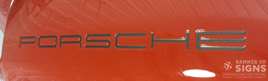Banner Up Signs created a metallic vinyl decal that says 'Porsche' 