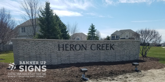 Dimensional text added to a brick wall announces a subdivision entrance.