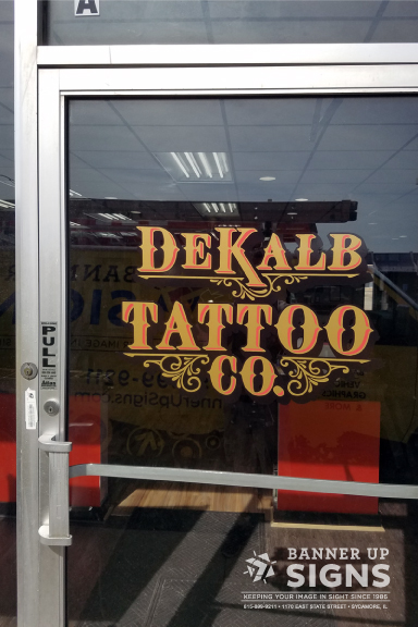 Layered in red and gold vinyl on the glass front door. DeKalb Tattoo Company trusts Banner Up Signs to make their logo really pop.