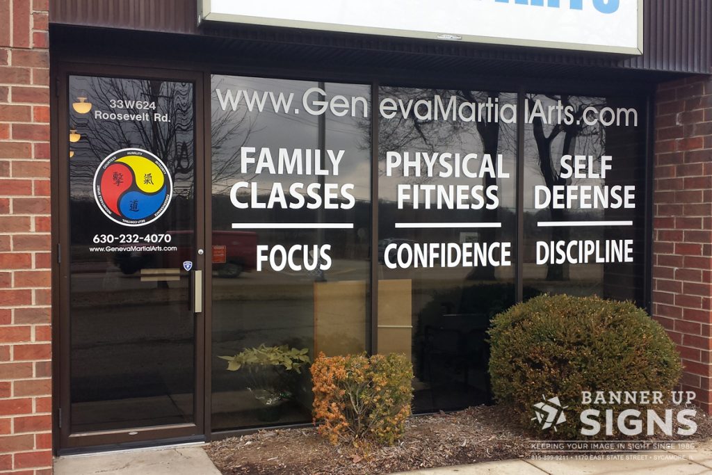 A local martial arts company showcases their classes and benefits on their windows to display.
