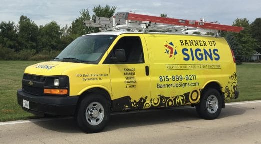 The Banner Up Signs yellow van is on its way to an installation job.